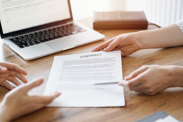 Businesswoman lawyer pointing into contract special points admitting something for colleague or client at the wooden desk in office. Business people teamwork and partnership, meeting concept