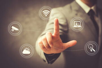 Businessman touching a touchscreen with icons for smart home technology
