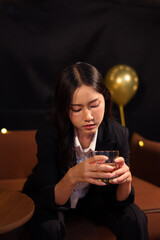  Closeup business woman holding a glass of whiskey