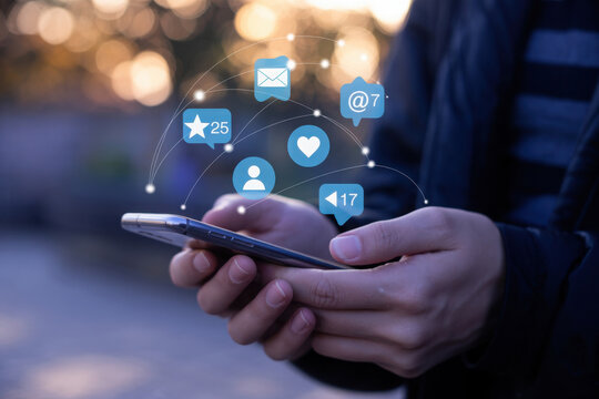 Hands holding smartphone with social media icons and network - Powered by Adobe