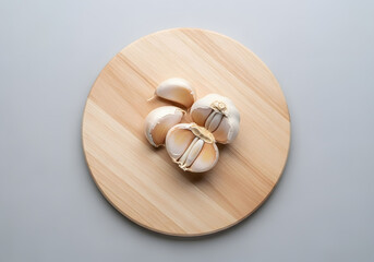 Fresh garlic bulbs and cloves on a wooden cutting board