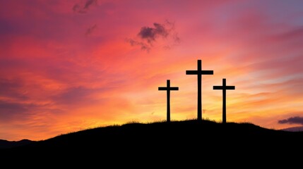 Three crosses silhouetted against a dramatic fiery sunset sky on a hilltop conveying a serene and spiritual atmosphere