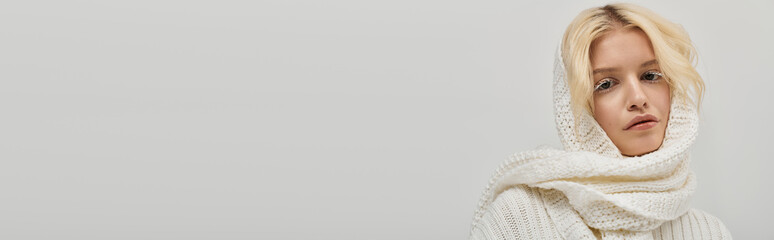 Cozy winter vibes from a young blonde woman in a stylish knitted sweater