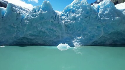 A sweeping aerial shot showcasing the immense scale of a majestic glacier winding through a rugged mountain range, highlighting its vast, untouched natural beauty. - Powered by Adobe