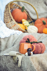 Pumpkin shaped mug of strong black coffee, cozy autumn interior with handmade decorations