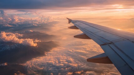 Airplane wing flying over clouds at sunset with warm light
