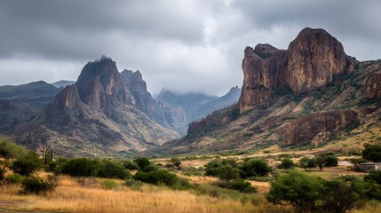Dramatic desert mountain range rises under an overcast sky above arid plains