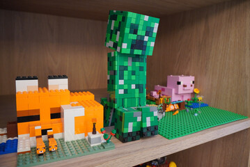 Naklejka premium Minecraft characters built with colorful toy bricks on a wooden shelf