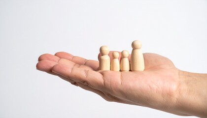 A person hand holding a collection of wooden figurines, depicting a family. These figures are arranged to represent a family unit.