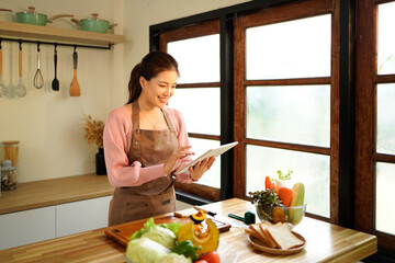 Tablet, kitchen and woman cooking recipe from website blog for home lunch, dinner or food. Digital technology, internet search and woman portrait chef with breakfast inspiration
