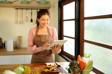 Tablet, kitchen and woman cooking recipe from website blog for home lunch, dinner or food. Digital technology, internet search and woman portrait chef with breakfast inspiration