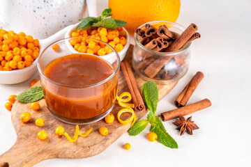 sea ​​buckthorn sauce with cinnamon, ginger and orange zest. Homemade autumn sauce, non sweet jam or chutney made with sea ​​buckthorn berries and spices, copy space