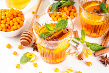 Hot autumn organic drink. Healthy diet beverage, immunity booster food. Sea buckthorn hot tea  drink with orange zest, cinnamon spices and honey in a glass cups
