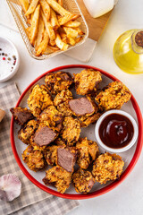 Beef Steak Nuggets Bites in crispy corn breading, cooked in an airfrier grill or oven. Healthy carnivore diet alternative nuggets. With barbecue sauce, spices and french fries potato chips