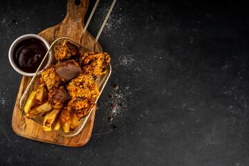 Beef Steak Nuggets Bites in crispy corn breading, cooked in an airfrier grill or oven. Healthy carnivore diet alternative nuggets. With barbecue sauce, spices and french fries potato chips