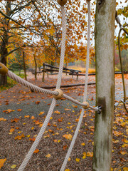 Detail of a modern rope and wooden playground structure in an autumnal city park