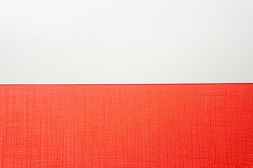 Fototapeta premium A minimalist geometric background split horizontally. The top is clean, smooth white, and the bottom is bright red textured paper. Simple modern abstract. 