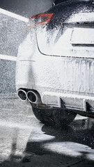 Luxury car covered in active foam during detailed wash process. Concept of car wash detailing...