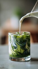 Iced matcha latte with milk swirling in glass, refreshing green tea drink, natural healthy beverage, artistic swirl texture and modern lifestyle concept.