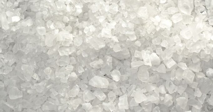 Coarse sea salt close-up footage on a rotating table.