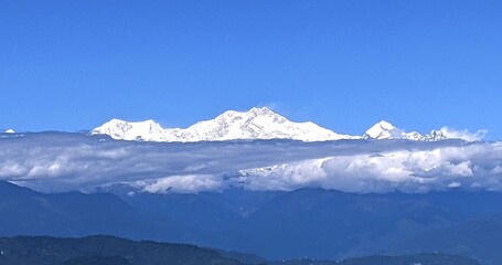 Fototapeta premium Majestic snow Covered kanchanjunga view mountain range of darjeeling hills perfect representation of himalayan beauty and peaceful mountain life in Darjeeling india clear blue sky landscape natural .