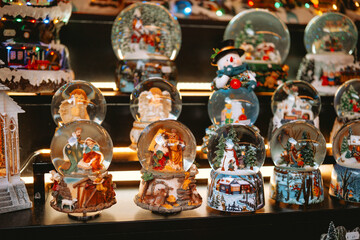 Collection of Christmas snow globes featuring nativities, snowmen, and winter scenes on display