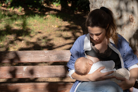 Mother breastfeeding a baby outdoors, creating a nourishing bond
