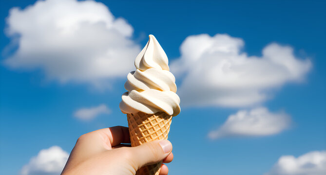 Hand Holding Ice Cream Cone Under Blue Sky