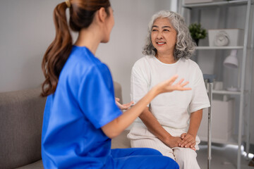 Obraz premium Asian adult nurse talks older patient home healthcare support professional visit elderly woman well-being senior care comfort communication residential living