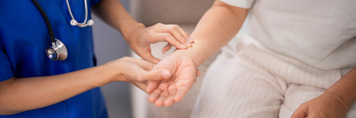 Adult nurse checking older adult patient pulse wrist home healthcare professional medical...
