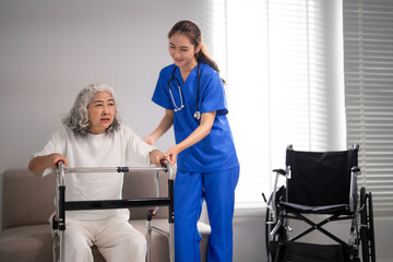 Obraz premium Asian adult nurse assists older Asian woman using walker for mobility support home care rehabilitation patient well being healthcare