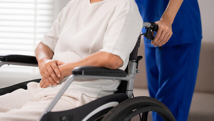 Nurse caregiver assisting older adult patient in wheelchair providing essential support healthcare facility for improved mobility comfort life