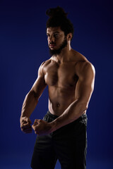 Fototapeta premium Sportive African American man showcasing strength against a vibrant blue backdrop