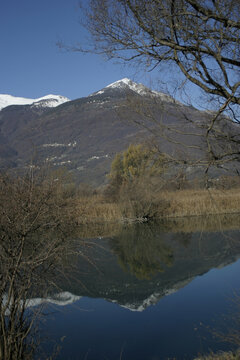 A mount reflected in the calm waters of Lake Como near Colico, Lombardy, Italy.