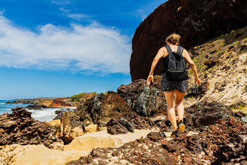 Female Hiker on Volcanic Landscape of Pohakumauliuli Beach, Molokai, Hawaii, USA