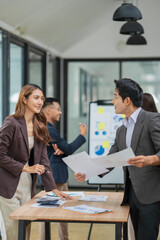 Group of Asian businesspeople sits down for a business investment planning meeting.	