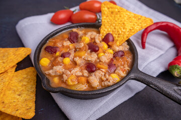 Delicious chili con carne in a pan served with tortilla chips
