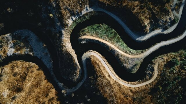 Aerial view of a winding mountain road with tight switchbacks cutting through rugged terrain. Concept Aerial landscape photography, Winding mountain road switchbacks, Rugged mountainous terrain