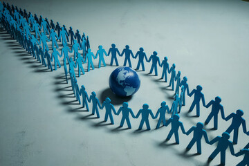 A Minimalist Social Diversity and Global Community Concept with Paper Figures Surrounding a World Globe
