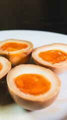 Soy-marinated ajitsuke tamago eggs halved on a plate, revealing creamy, succulent yolks. Perfect for ramen topping or appetizer. Rich, flavorful, and authentic.
