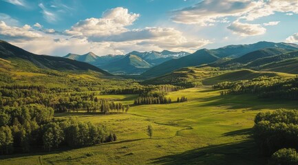Mountain valley, lush green meadows, and distant peaks under a partly cloudy sky