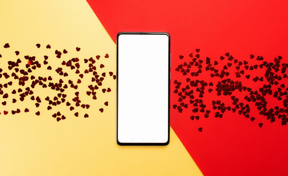 Phone surrounded by hearts on a yellow and red background