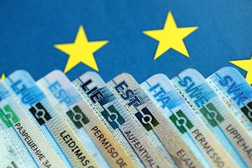 Permanent resident or residence permit cards lies on European Union flag. Paper specimen cards close up