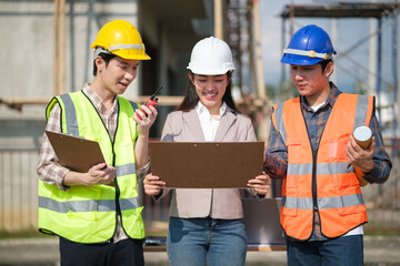 Construction team inspects documents and communicates on site, aligning schedule, safety, and quality control for a building project.