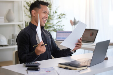 Excited businessman celebrating success while reading financial report in office.