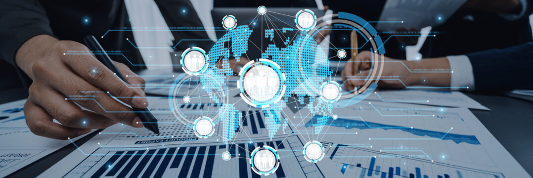 Business professionals focus on data charts and reports in an office setting, utilizing a digital interface to visualize global connections and strategies for growth. Trope - Powered by Adobe