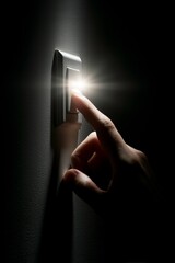 Hand flipping a light switch in darkness with bright illumination concept