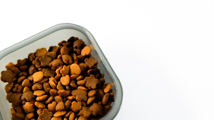 Dry pet food close up, cat kibble pile in gray plastic bowl isolated on white background
