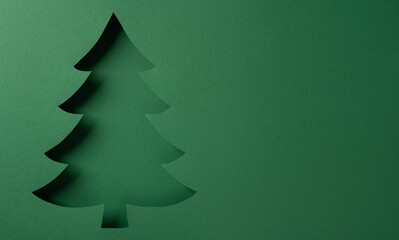 A minimal green Christmas tree cutout stands against a smooth green backdrop, evoking holiday spirit and festive greeting for Christmas and New Year celebrations, ideal for seasonal design