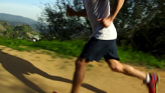 Close up of athlete running up a mountain